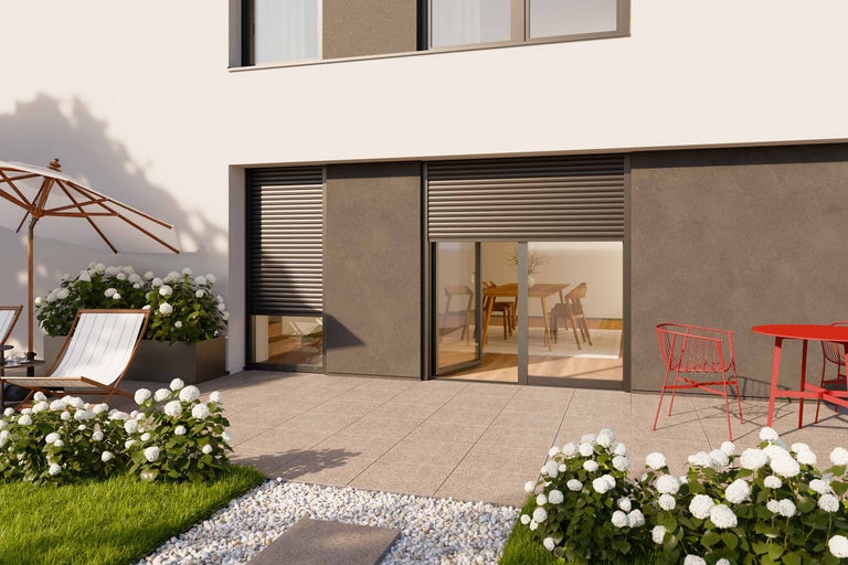 Terrass med rullgardiner, trädgårdsmöbler och blomsterrabatter