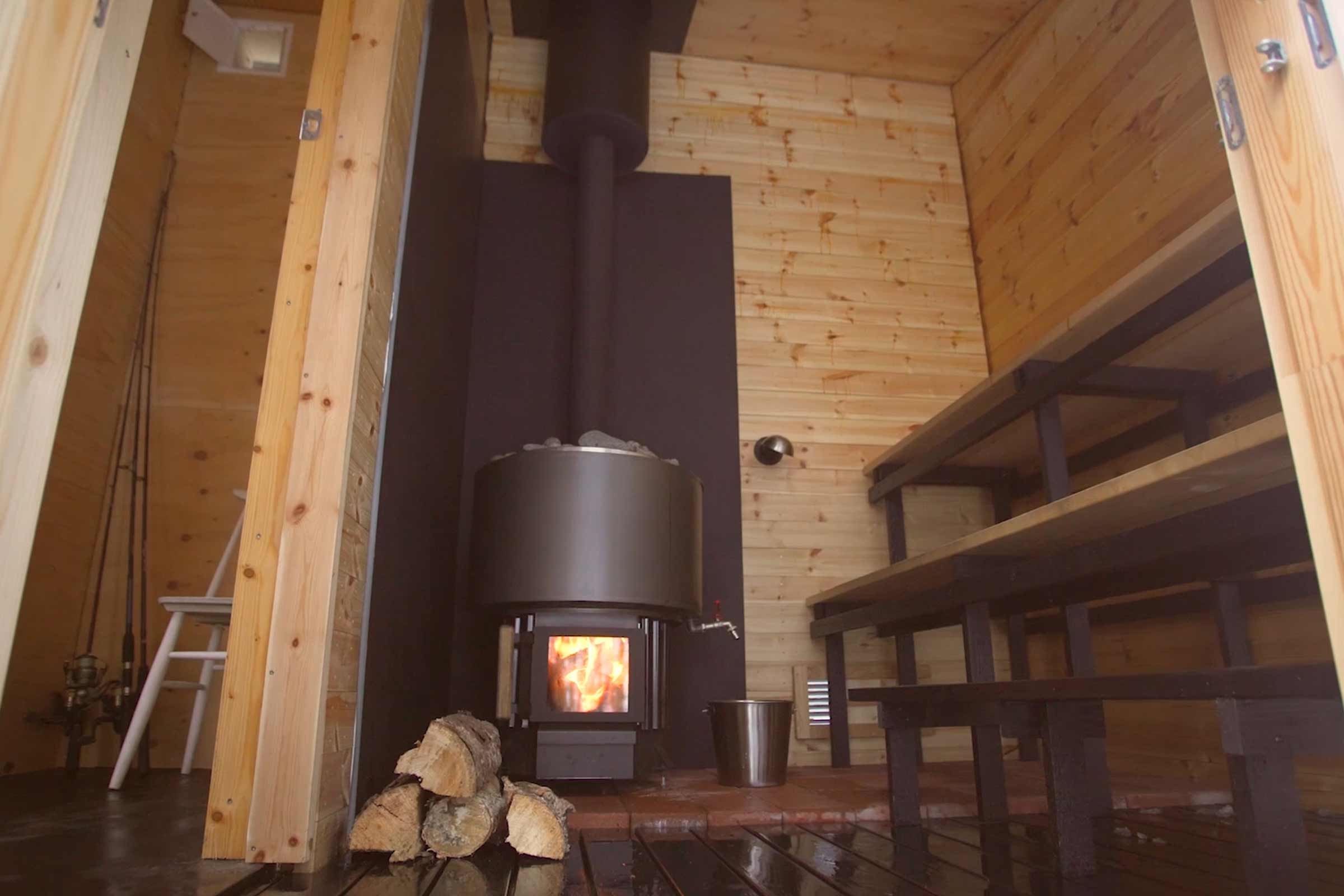 Bastu i trä med vedeldad kamin och bastubänkar