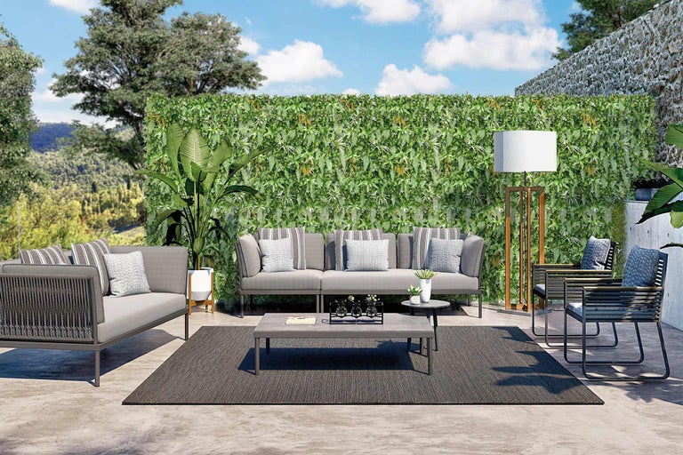 Uteplats med soffa, fåtöljer, bord, matta och växtvägg