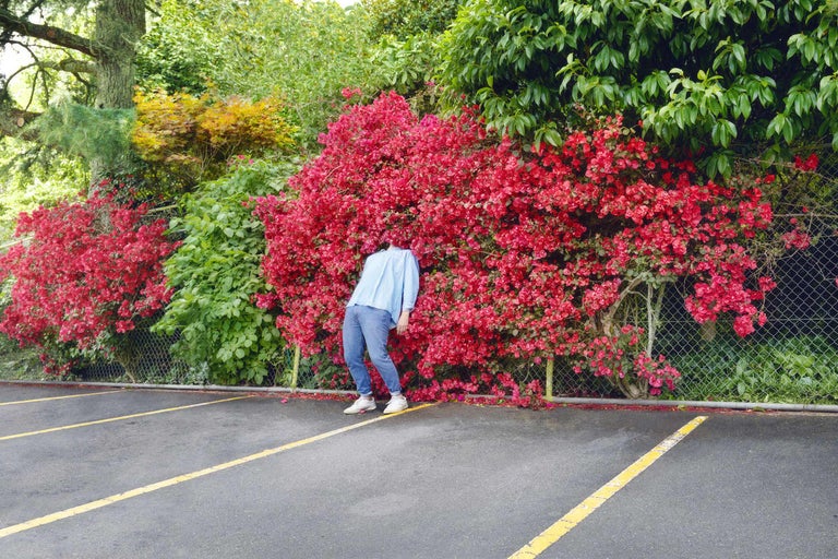 Person som står utomhus framför en blommande bougainvillea