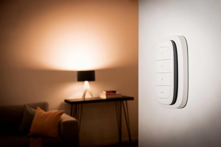 Smart väggbrytare för ljusstyrning i ett vardagsrum.