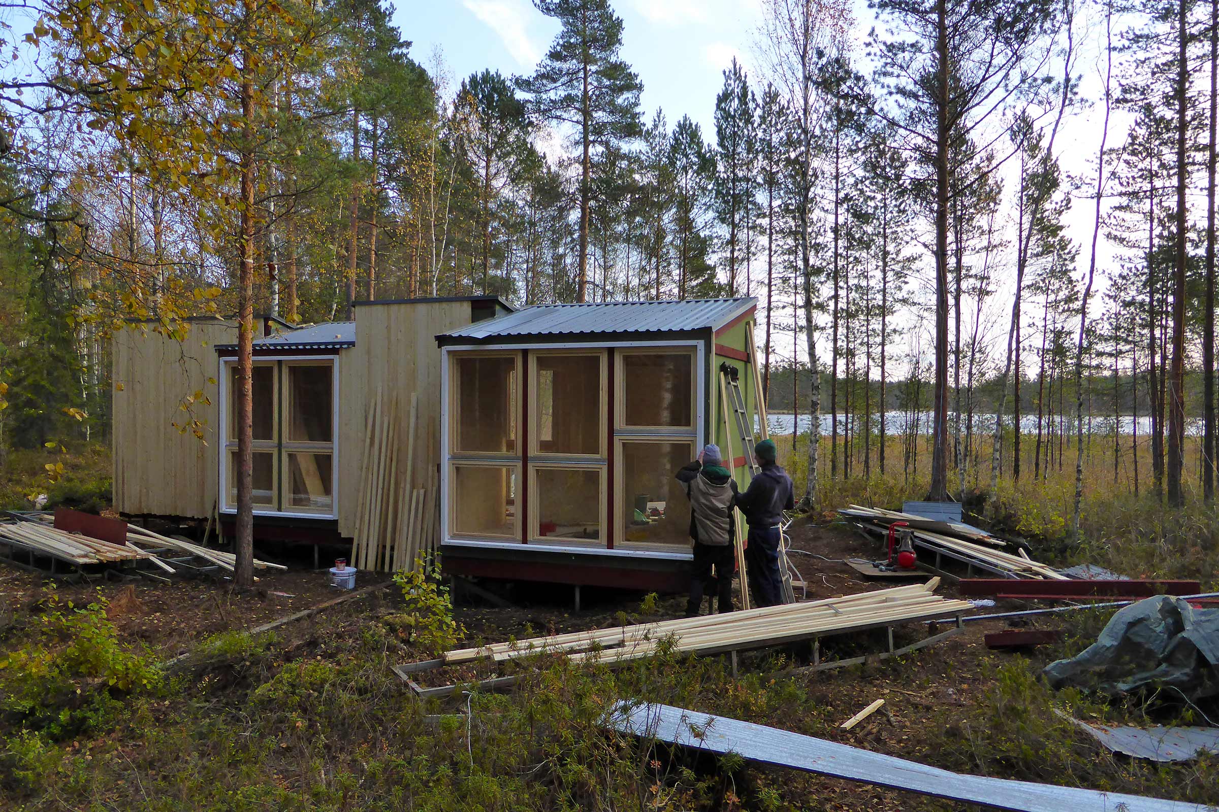 Trähus under uppbyggnad i skogslandskap