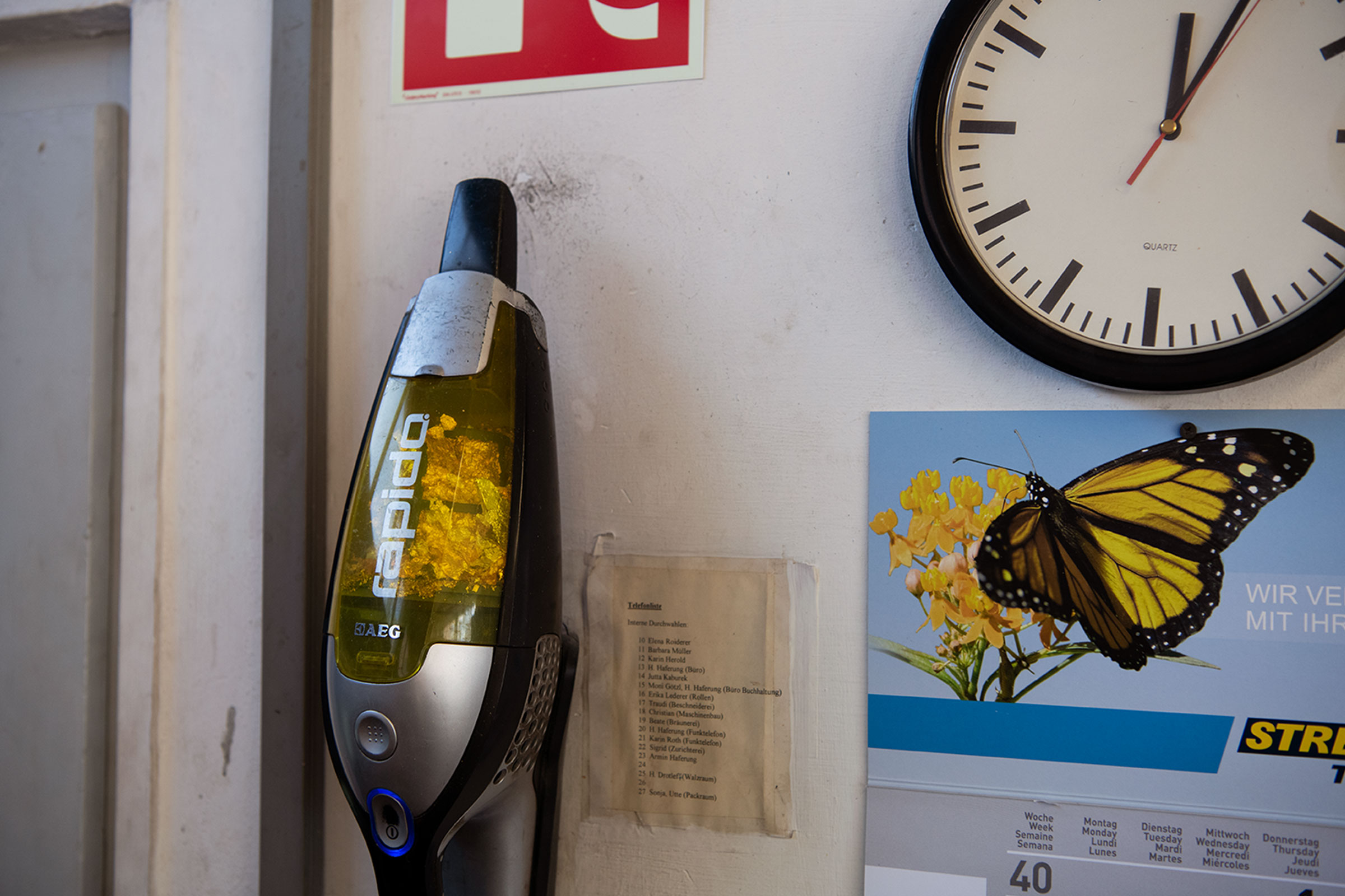 Sladdlös dammsugare från AEG, väggklocka, telefonlista och kalender hänger på väggen