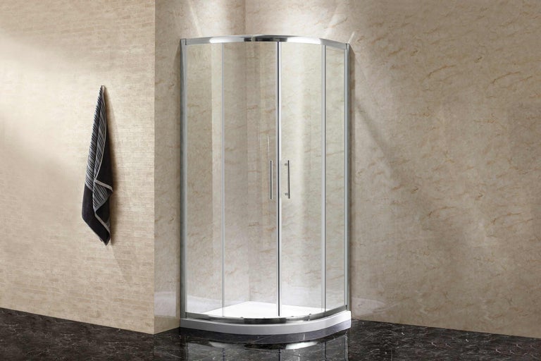 Fristående duschkabin med glasdörrar och handduk på kroken på väggen.