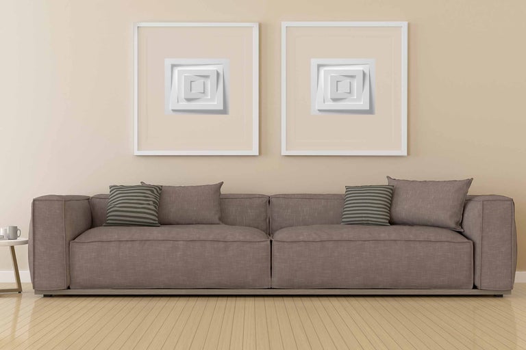 Vardagsrum med soffa och två inramade, tredimensionella väggdekorationer