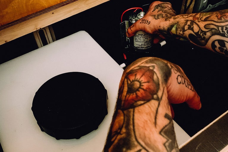 Vattentank med pump och tatuerade händer