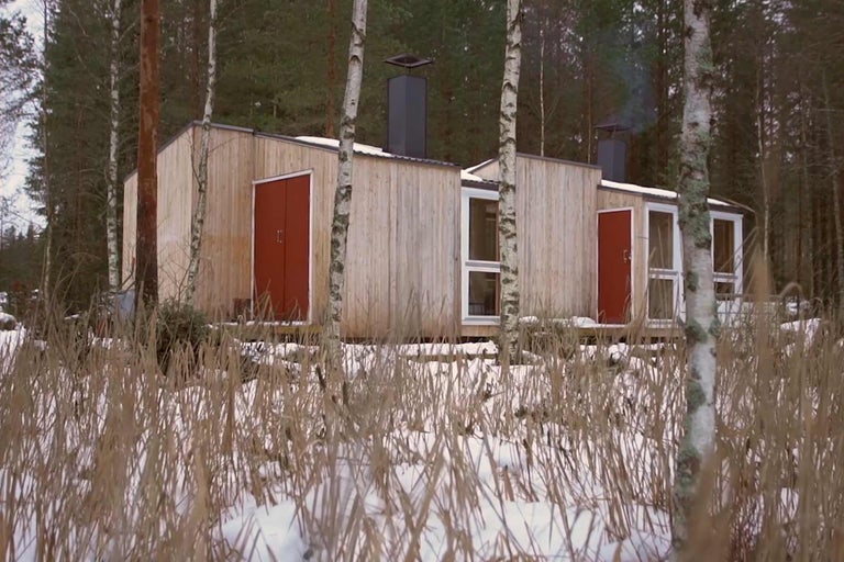 Trähus med skorsten i vinterlandskap