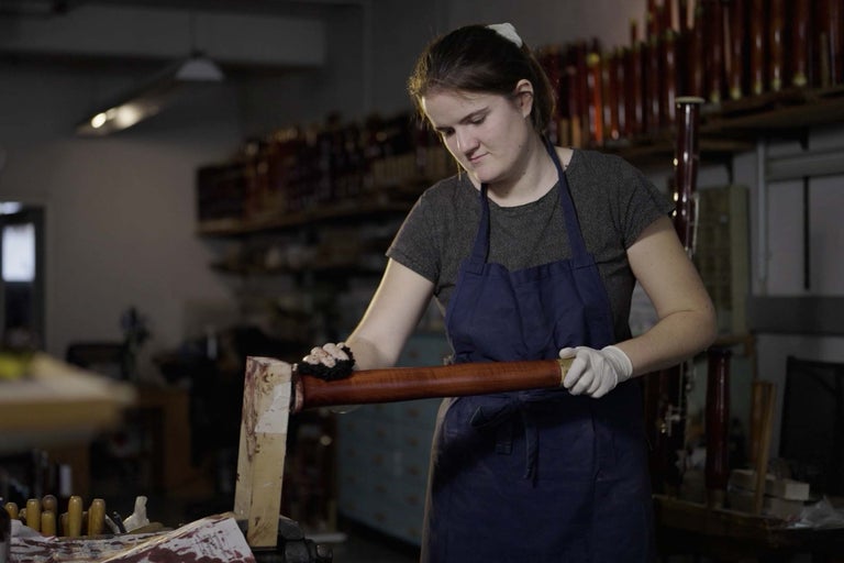 Kvinna bearbetar trästav i verkstad