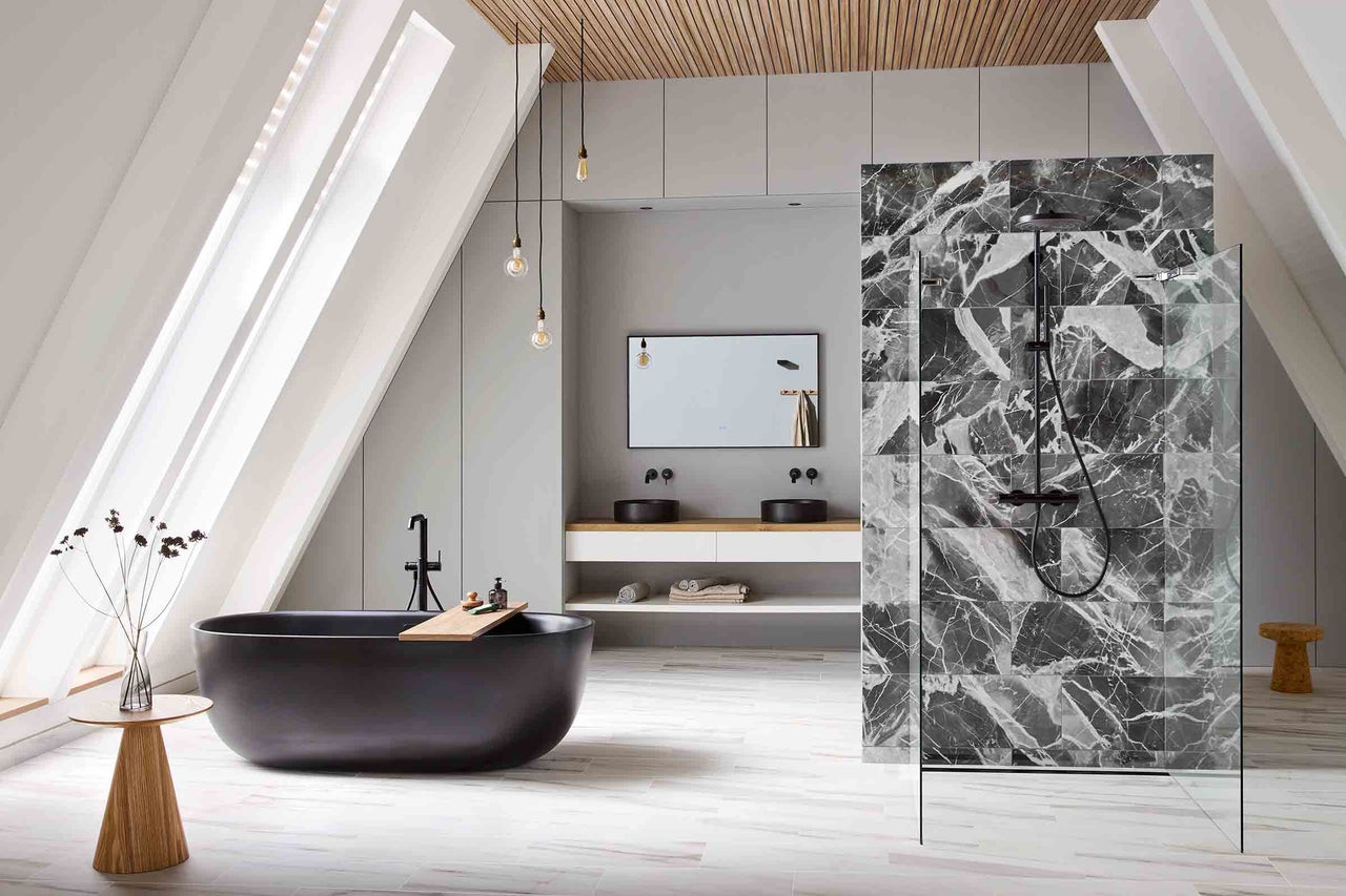 Ljust badrum med badkar, dusch och tvättställ under snedtak