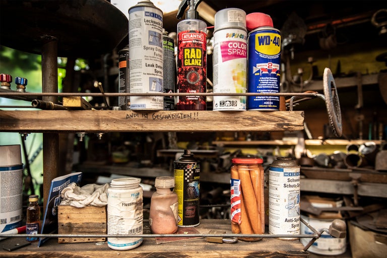 Hylla med diverse sprayer och verkstadsredskap