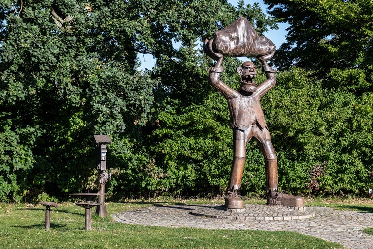Skulptur av en figur som håller en sten över huvudet