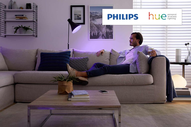 Vardagsrum med Philips Hue-belysning och avslappnad man i soffan