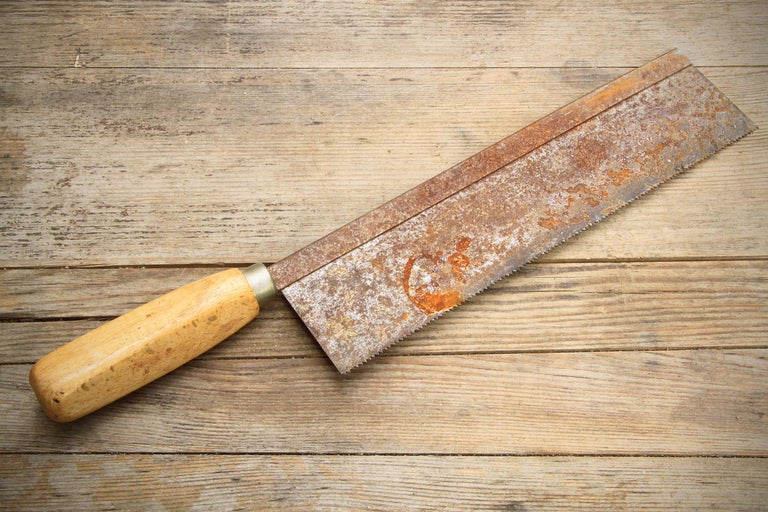 Handsåg med trähandtag på träbord