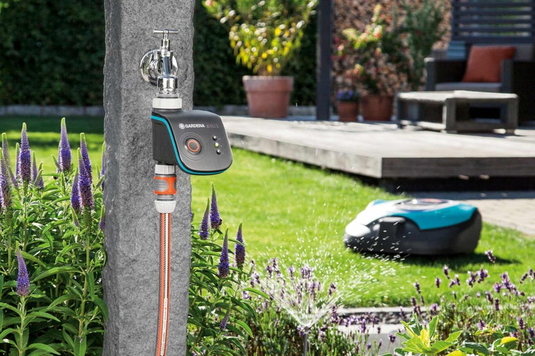 Gardena Smart Water Control bevattningsstyrning på vattenkranen med robotgräsklippare i trädgården