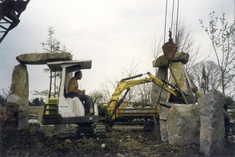 Konstruktion av en stenskulptur med grävmaskin och kran