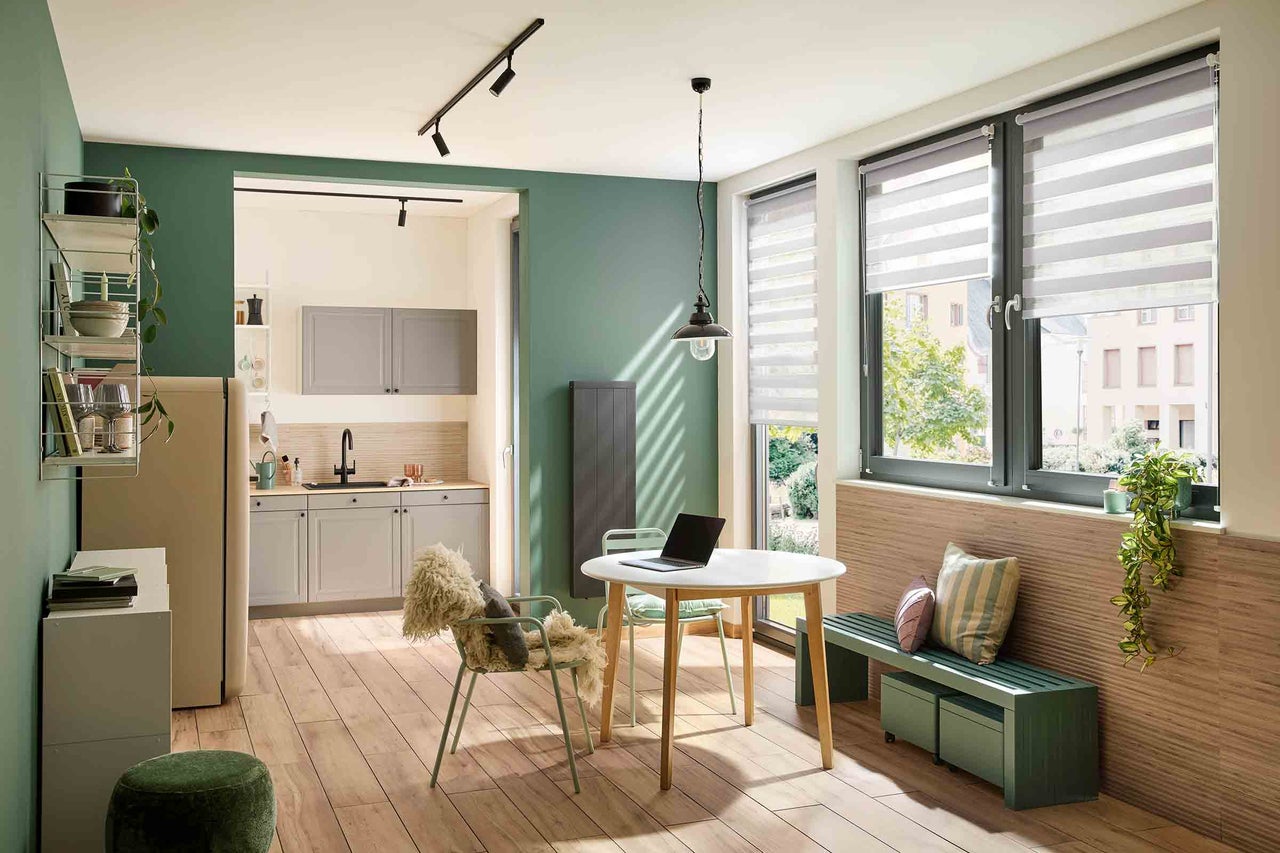 Ljust vardagsrum med matbord, stolar och pentry