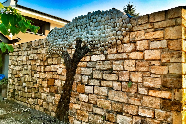 En mur av sandsten med en träddekoration av småsten.