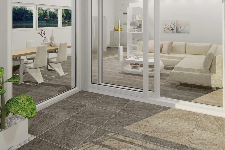 Ljust vardagsrum med matbord, soffa och klinkergolv.