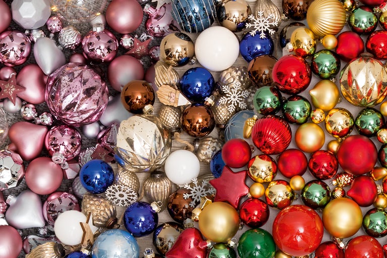 Närbild av en mängd olika julgranskulor och dekorationer i olika former och material.