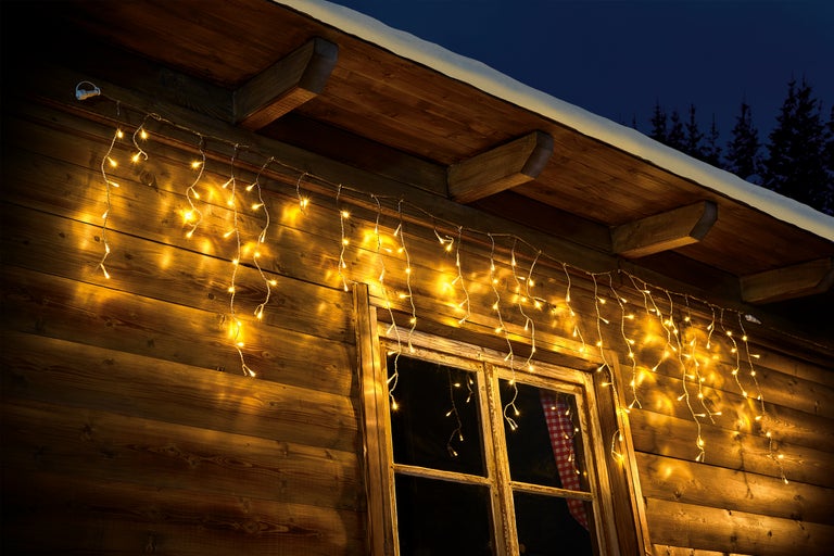 Träfasad med fönster och ljusslinga som dekoration