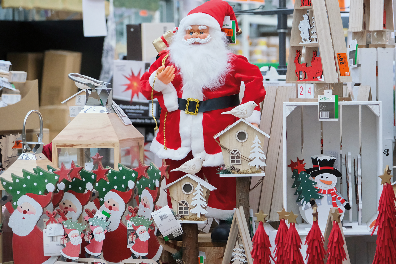 Dekorativ jultomte med juldekorationer som lyktor, fågelholkar och träfigurer.