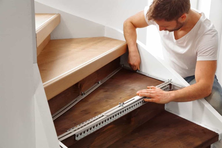 Man monterar trätrappa med metallfästen
