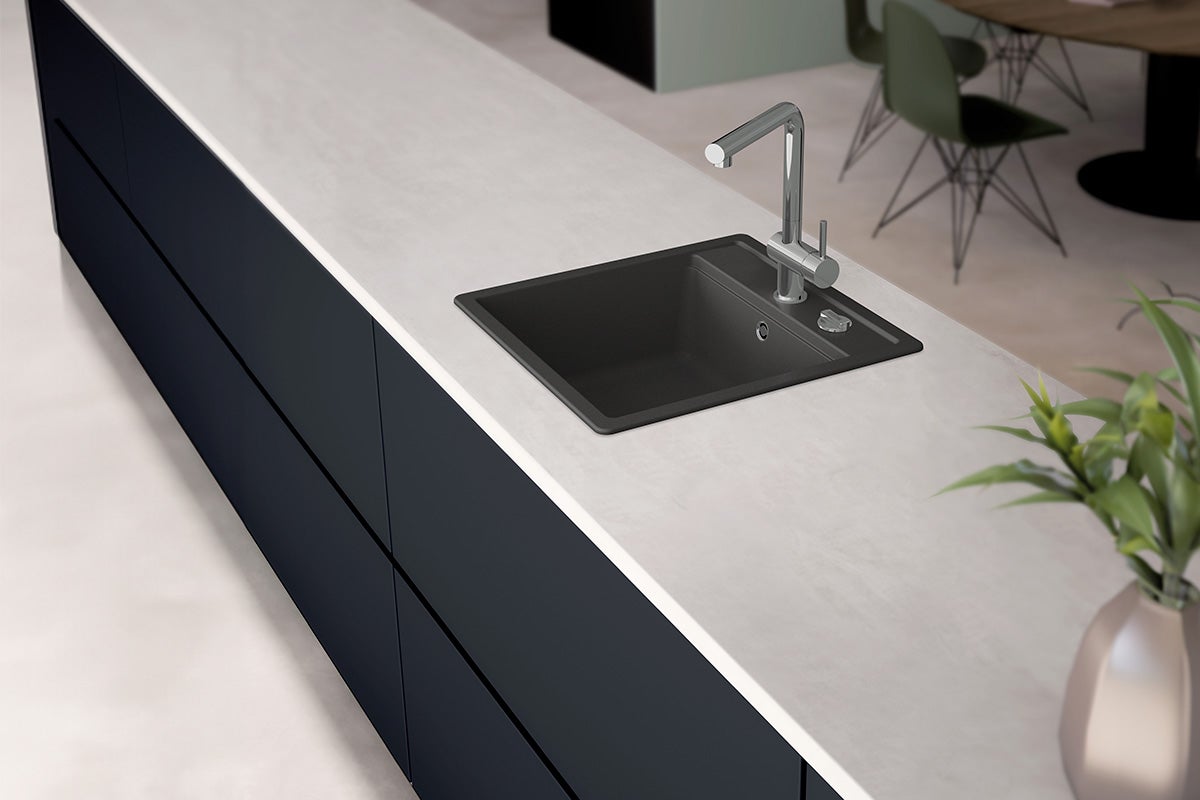 Köksscen med diskho, kran och bänkskiva.