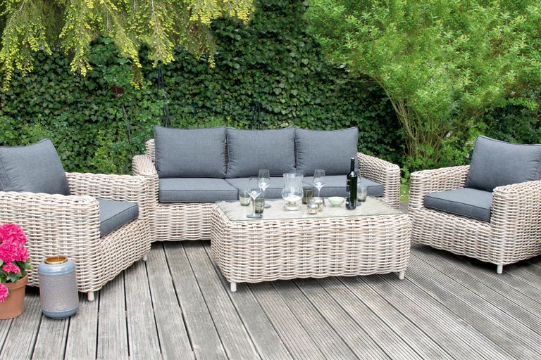 Utemöbelset med soffa, fåtöljer och bord på en träaltan