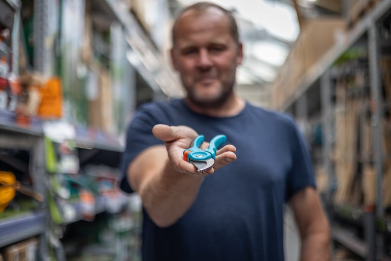 Man håller en grensax i handen i byggvaruhuset.