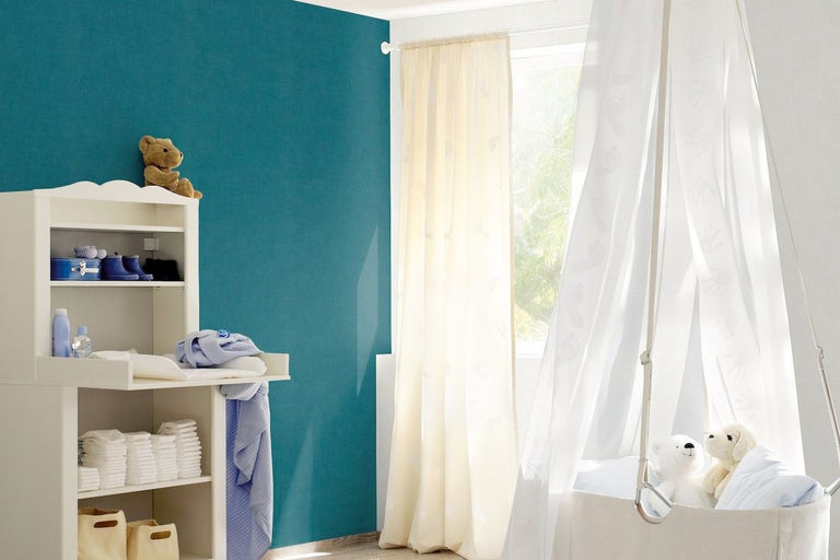 Ljust barnrum med skötbord, gardiner och babyvagga