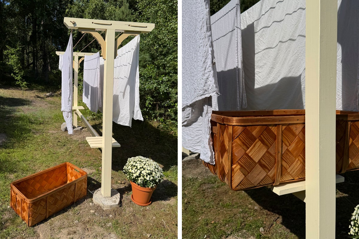 Ljus utomhusmiljö med en torkställning i trä, hängande tvätt, en flätad korg och en krukväxt i en trädgård.
