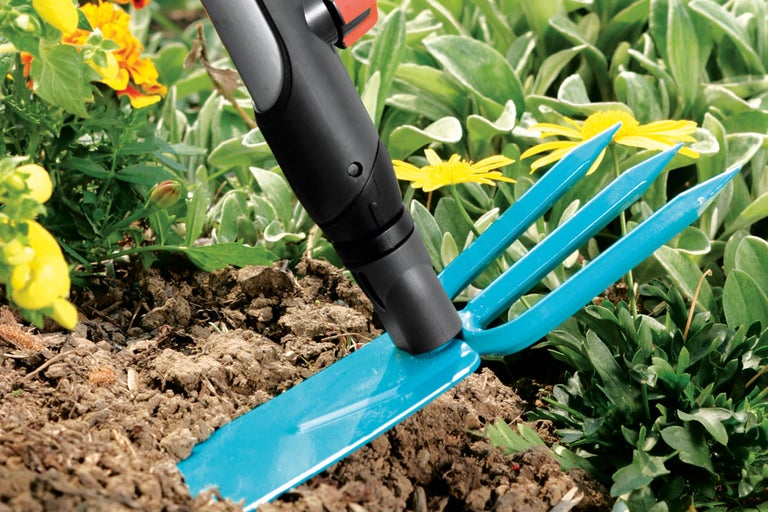 Trädgårdsgrep i bruk i en blomsterrabatt