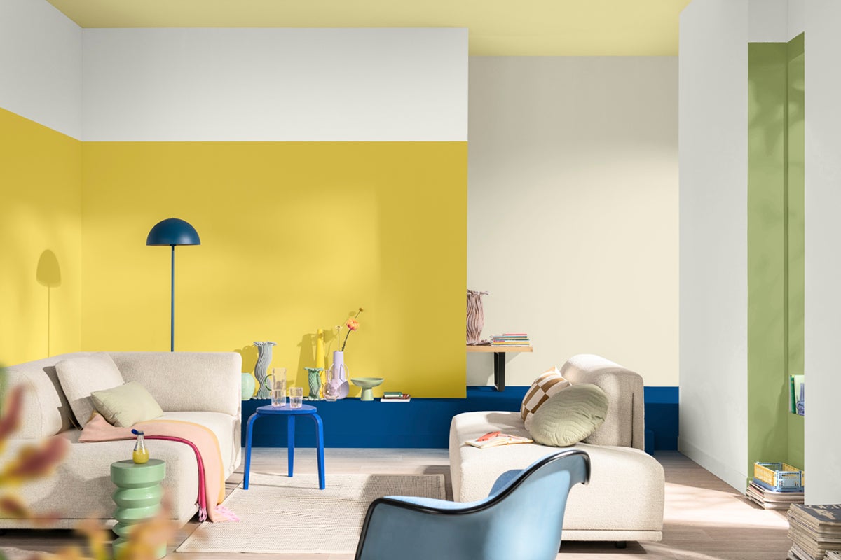 Ljust vardagsrum med soffa och färgade accenter på väggar och möbler