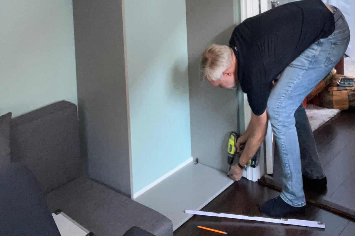 En man monterar en möbel med en sladdlös skruvdragare.