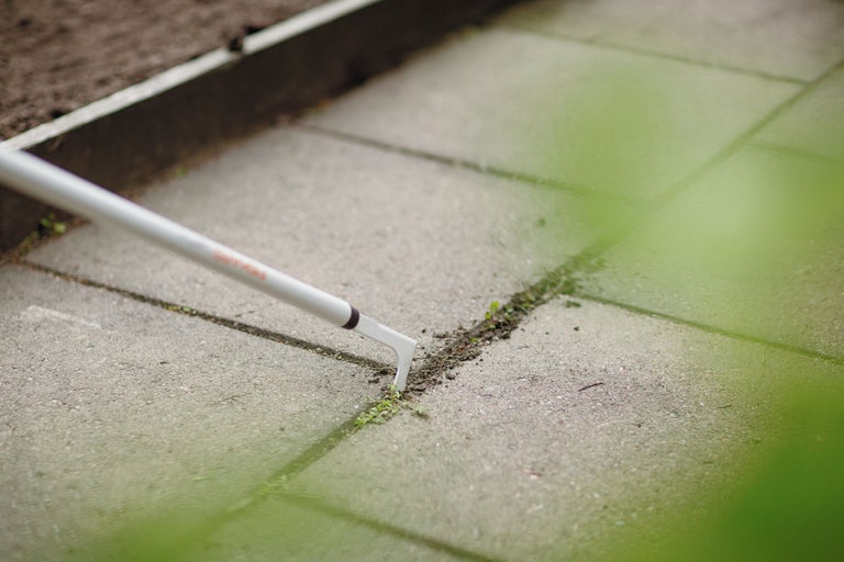 Ogräsrensare i bruk på stenläggning