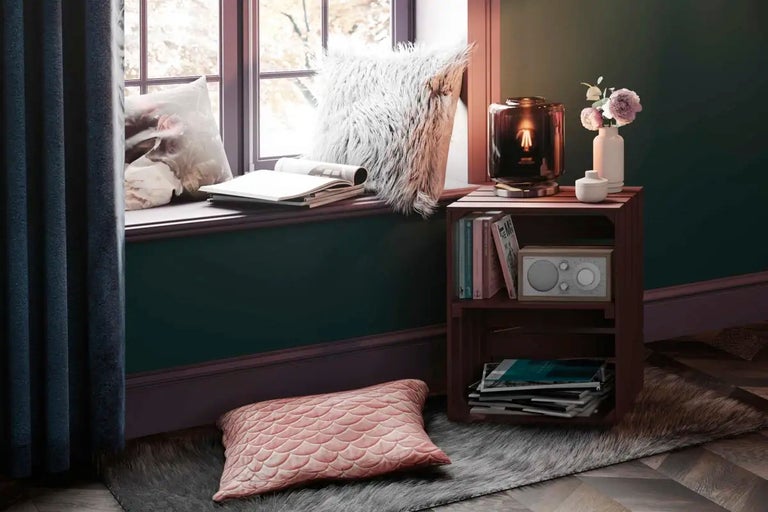Mysig läshörna med fönster, kuddar, lampa och hylla