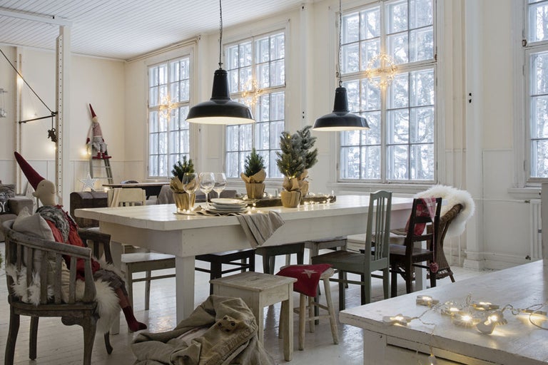 Juldekorerad matplats med matbord, stolar och pendellampor.