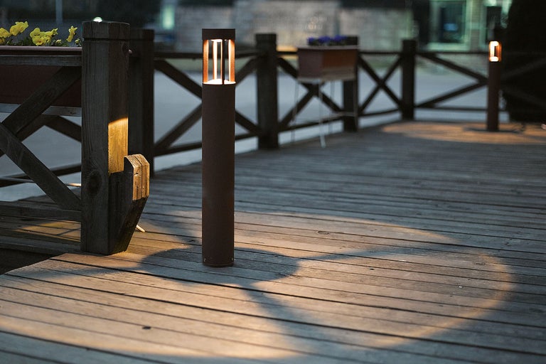 Dekorativ gångvägsbelysning av metall på en träterrass