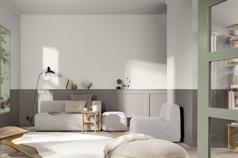 Ett modernt inrett vardagsrum med soffa, sidobord, golvlampa och väggpaneler i en ljus, minimalistisk stil.