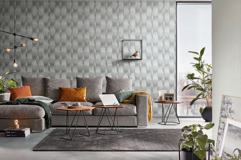 Vardagsrum med soffa, bord och mönstrad tapet för en modern inredningsdesign