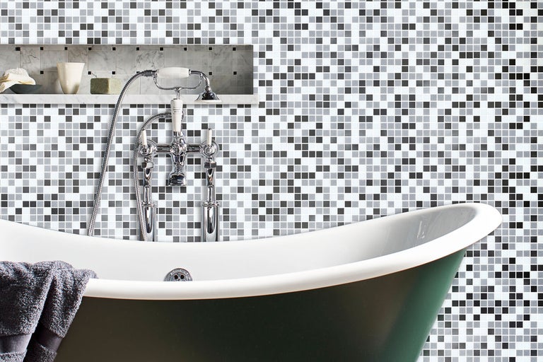 Badrum med mosaikvägg och fristående badkar