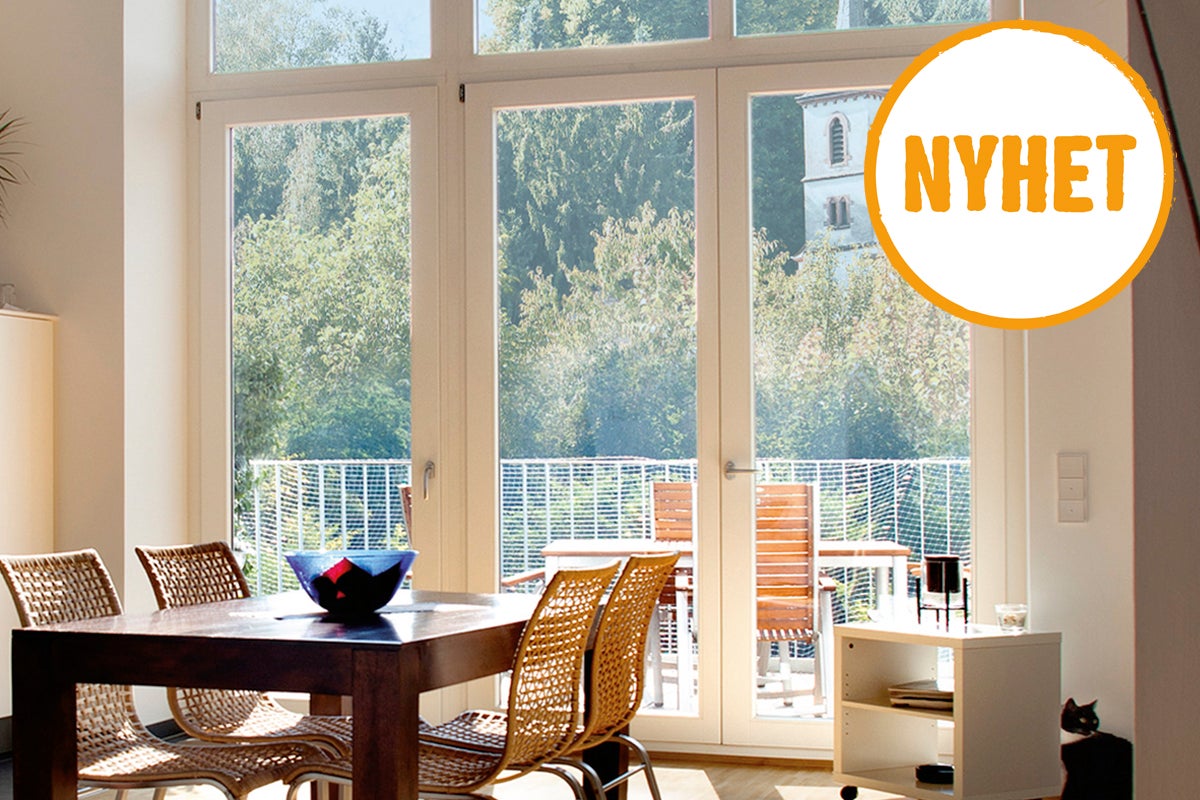 Ljust vardagsrum med matbord, stolar och balkongdörr med utsikt över grönområde