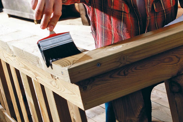 Målning av ett trästaket med en pensel