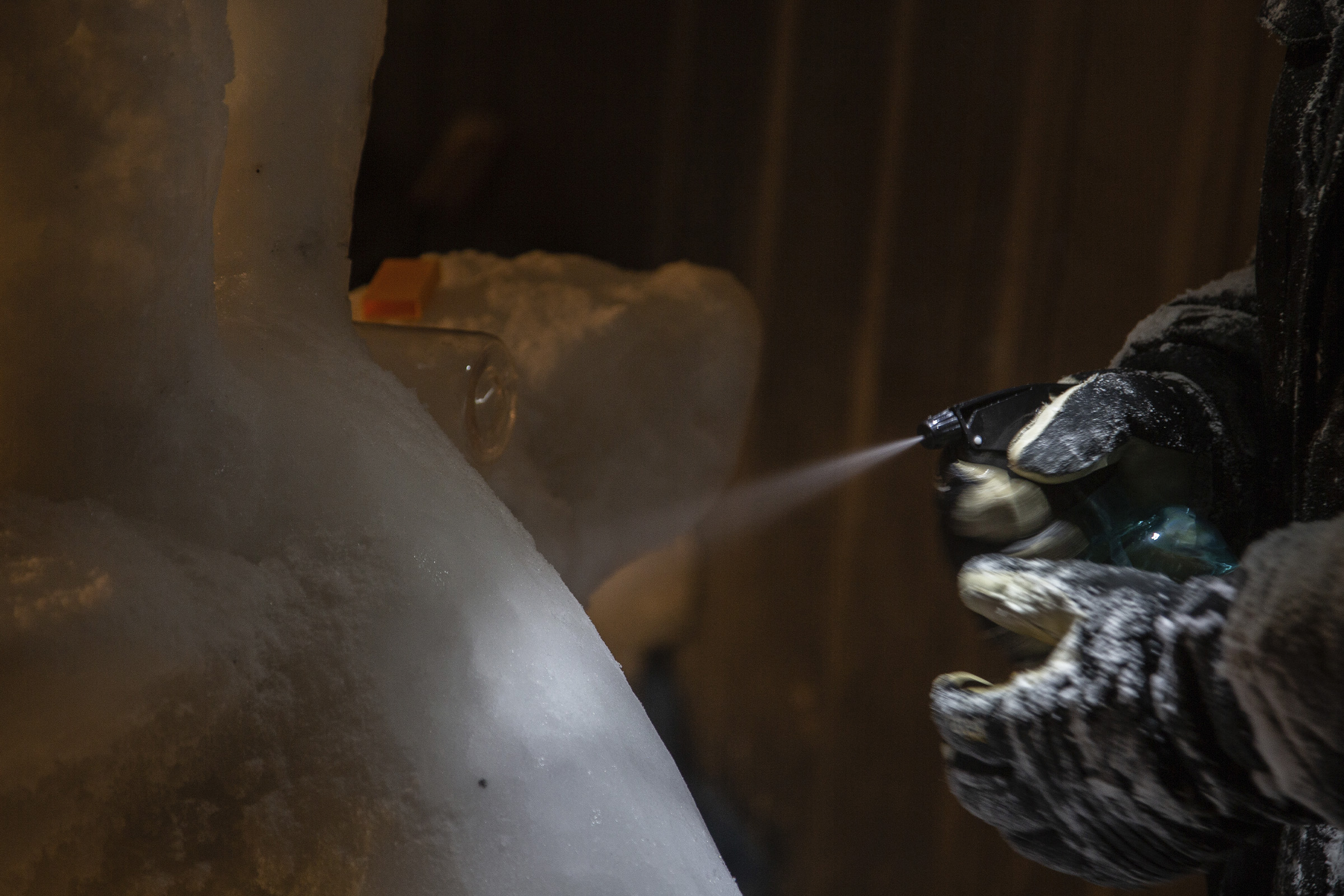 En person sprayar en isstruktur med en sprayflaska.