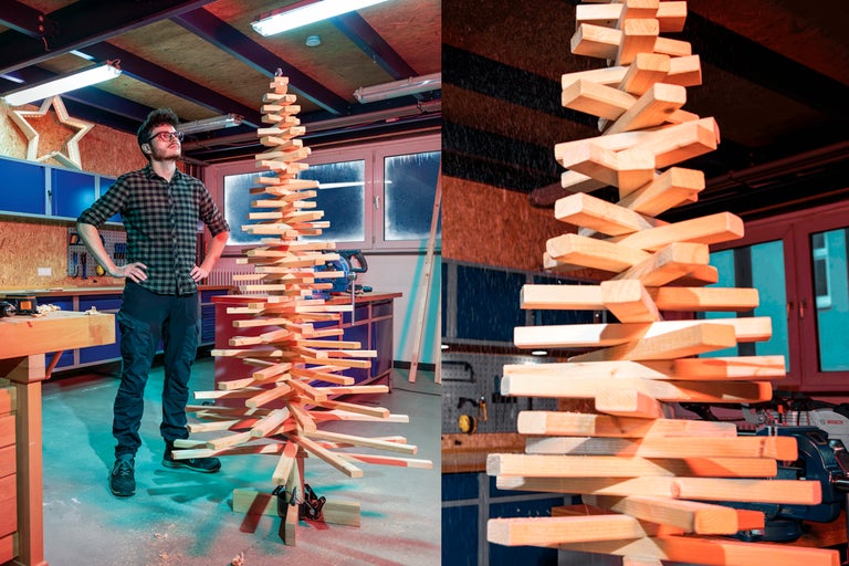Man tittar på en hemgjord julgran av träribbor i en verkstad.