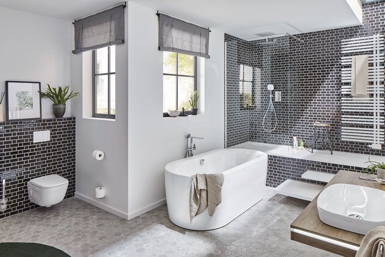 Modernt badrum med badkar, dusch, handfat och toalett