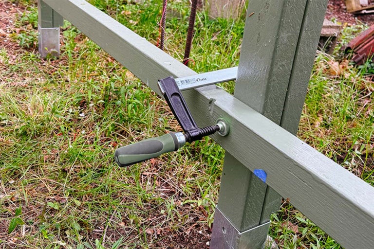 Detaljvy av en grundram med handvev och skruvankare i trädgården