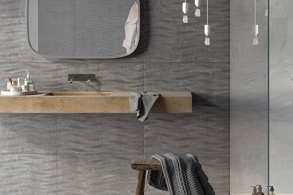 Modernt badrum med gråa kakelplattor, tvättställ i trä och spegel