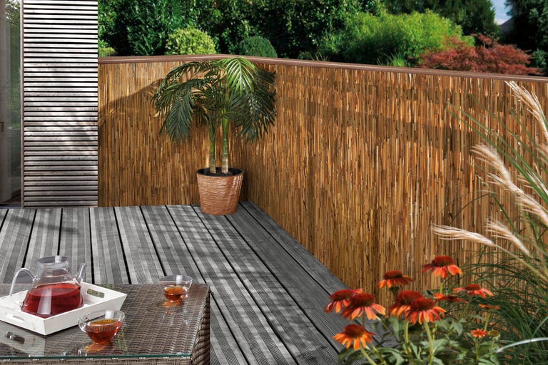 Bambus insynsskydd på en terrass med bord och dekoration
