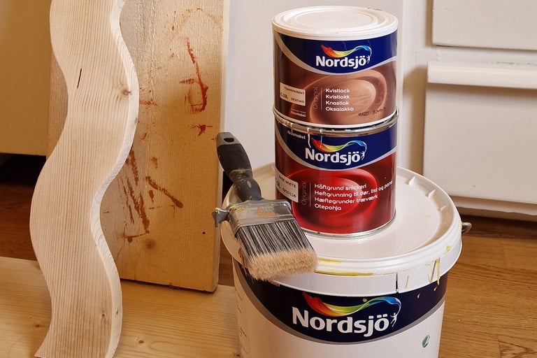 Färghink, pensel och träelement för träbearbetning.